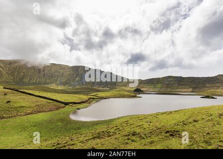 Pareti di roccia nella distanza del Corvo caldera sull isola di Corvo nelle Azzorre, Portogallo. Foto Stock