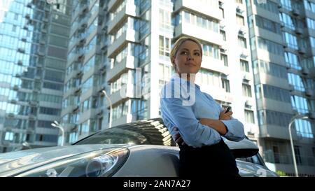 Donna di successo acquista auto di lusso, accende car alarm, cenno di approvazione, ricchezza Foto Stock
