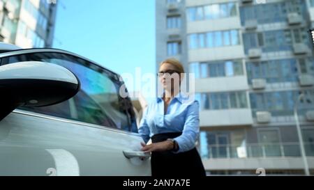 Donna occupata uscendo dalla vettura la chiusura della porta, fretta per business meeting Foto Stock