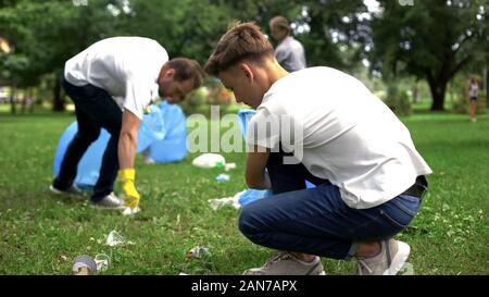 La gente di prelevare i rifiuti in un sacchetto di plastica, il trattamento dei rifiuti il problema, riciclaggio Foto Stock