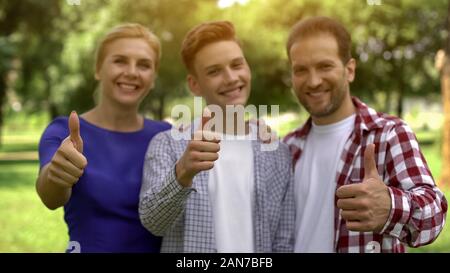 Famiglia allegra sorridente mostra Thumbs up, lucrativi di prestiti, crediti per studiare Foto Stock