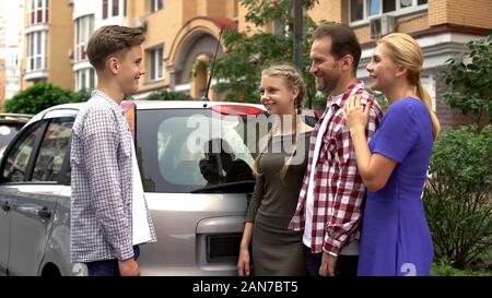 I genitori gifting nuova auto per amare nostro figlio adolescente, il regalo perfetto per il compleanno Foto Stock
