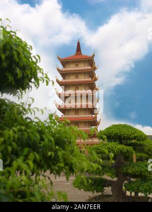 Tall pagoda di Vinh Trang tempio, vicino a My Tho, Vietnam. Basso angolo vista dai giardini. Foto Stock