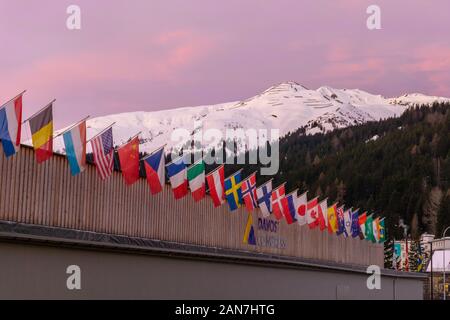 Davos GR / Svizzera - 14 Gennaio 2020: il centro congressi a Davos con le bandiere delle nazioni di sunrise durante il WEF Forum Economico Mondiale Foto Stock