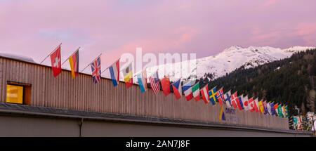 Davos GR / Svizzera - 14 Gennaio 2020: il centro congressi a Davos con le bandiere delle nazioni di sunrise durante il WEF Forum Economico Mondiale Foto Stock