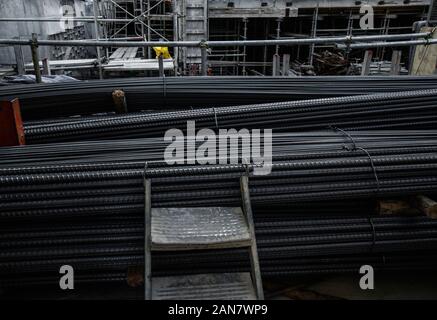 Edificio ancora nel magazzino dei prodotti metallurgici o sul sito in costruzione. Pila di metalli pesanti barre di rinforzo con profilo periodico Foto Stock