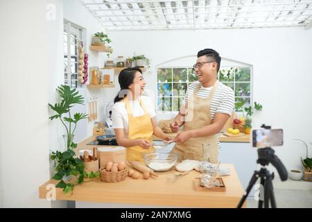 Giovani asiatici giovane cucinare insieme e la registrazione di video live per vlog e social media con telecamera professionale Foto Stock