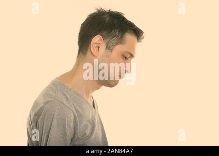 Studio shot del giovane uomo con barba stoppie isolata contro uno sfondo bianco Foto Stock