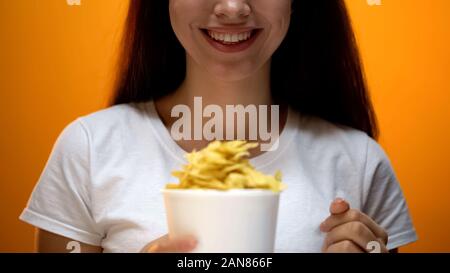 Donna che mantiene chips, sapori artificiali in alimenti causare dipendenza, i rischi per la salute Foto Stock