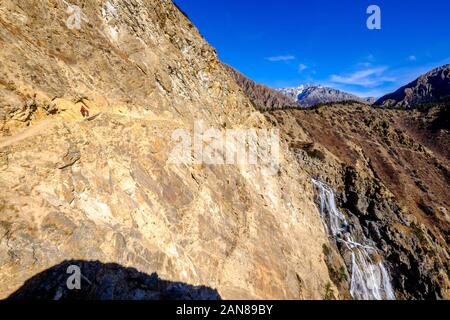 Popolo tibetano sul sentiero tagliato in montagna sul Basso circuito di Dampo Trek vicino Ringmo / Phoksundo, Nepal Himalaya Foto Stock