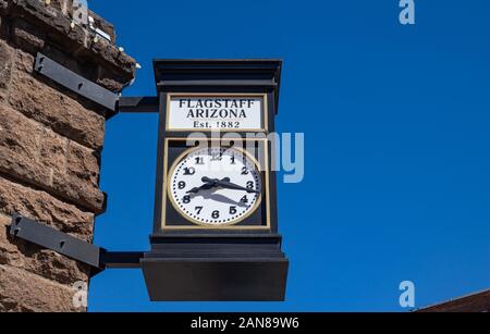 Flagstaff, in Arizona, Stati Uniti d'America. Maggio 25, 2019. Una strada orologio analogico, su un edificio in pietra è il timekeeper per i cittadini. Un vintage, metallo, round watch onu Foto Stock