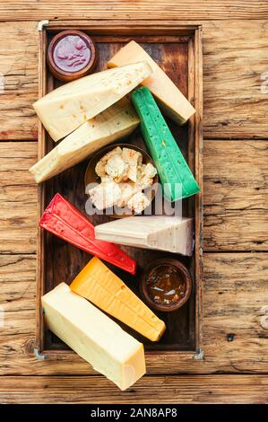 Vari tipi di formaggio servita in una scatola di legno.vari tipi di formaggio su tavola in legno rustico Foto Stock