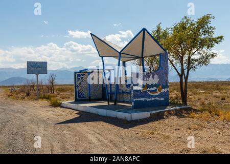 Svuotare fermata bus sulla strada, luogo di attesa per il bus, Issyk-Kul Lago, Kirghizistan Foto Stock