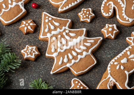 A forma di albero e altro Natale gingerbread cookie su sfondo scuro Foto Stock