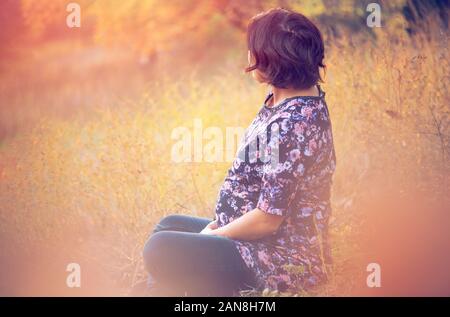Ritratto di bella donna incinta nella natura Foto Stock