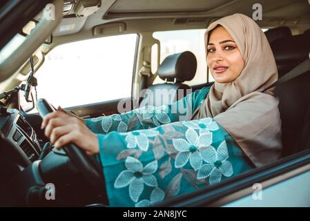 Bella donna di Dubai indossando abaya tradizionale abito femminile alla guida della vettura. Concetto di uae e i diritti delle donne Foto Stock