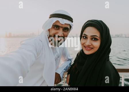 Coppia felice di Dubai a godersi il tramonto con la vista dello skyline di Foto Stock