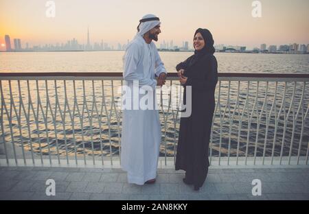 Coppia felice di Dubai a godersi il tramonto con la vista dello skyline di Foto Stock