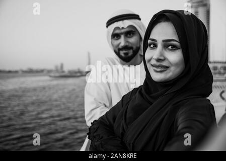 Coppia felice di Dubai a godersi il tramonto con la vista dello skyline di Foto Stock