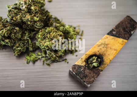 Chiudere il fuoco selettivo sulla marijuana e lo sfondo della tubazione Foto Stock