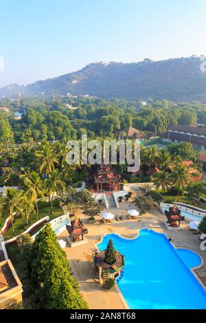 Vista di Mandalay Hill dietro i giardini e i dintorni del Mandalay Hill Resort hotel con la sua pagoda e piscina, Mandalay Myanmar (Birmania) Foto Stock