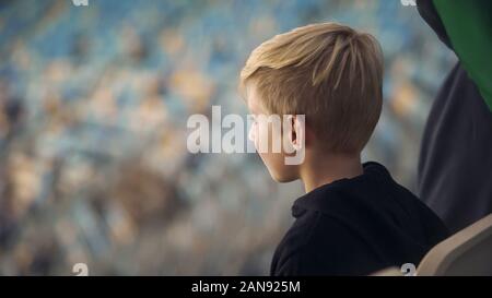 Little Boy la visione di gioco di sport stadium, supporto di squadra preferita, close-up Foto Stock