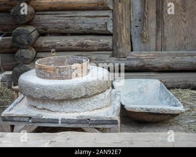 Rotante mulino discoidale di pietra per mano-macinazione di un grano in farina. Medievale a mano azionato macina macinazione del grano. L'antica pietra Quern mulino a mano con Foto Stock