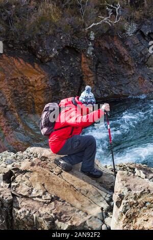 L'uomo sulle rocce al pool di Fairy, fiume fragile, Isola di Skye in Scozia, nel Regno Unito nel mese di marzo Foto Stock