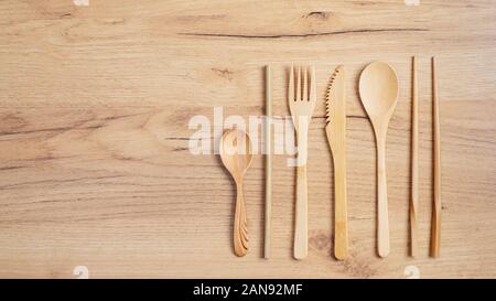 Utensili di bambù set di posate. Posate riutilizzabili set da viaggio. Eco-friendly argenteria in legno su un tavolo di legno. Appartamento laico, vista dall'alto. Rifiuti Zero, plastica libera Foto Stock