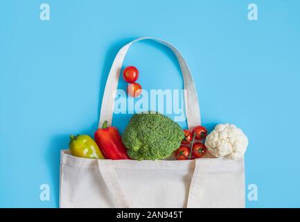 Rifiuti Zero concetto. Verdure in eco-friendly tessile riutilizzabile borsa su sfondo blu. Libero di plastica. Sani e freschi cibi vegetariani. Lay piatto Foto Stock