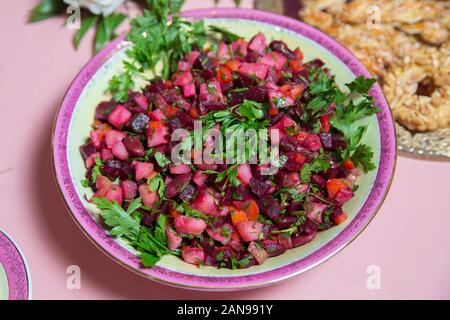 Freschi Fatti in casa Insalata di barbabietole da insalata in una ciotola bianco. Insalata di verdure con bietole sul tavolo pronto per mangiare . barbabietole con Insalata di carote, sottaceti Foto Stock