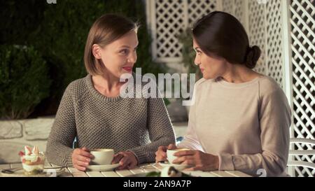 Belle ragazze parlano in cafe, femmina amici di trascorrere del tempo insieme Foto Stock