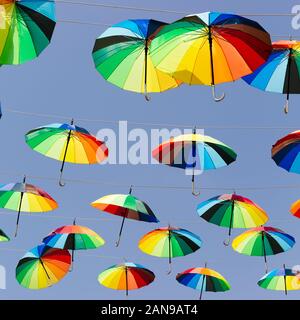 Molti rainbow ombrelloni messi di fronte alla strada Foto Stock