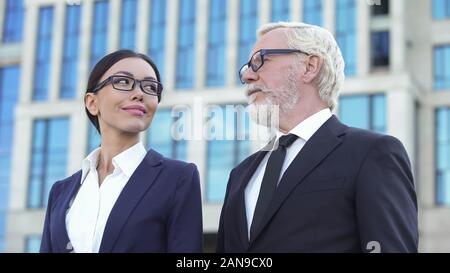 Imprenditore Senior e la giovane donna in tuta cercando ogni altra società teamwork Foto Stock