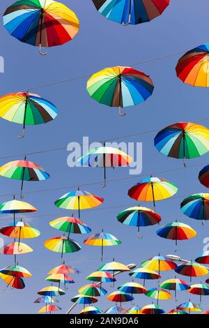 Molti rainbow ombrelloni messi di fronte alla strada Foto Stock