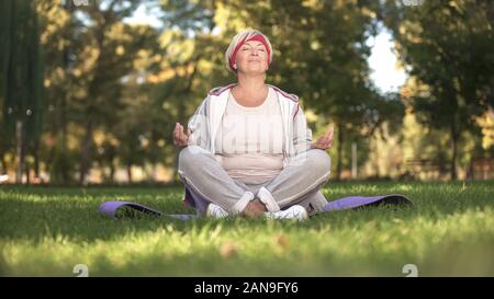 Medioevo donna profondamente la respirazione e la meditazione seduta nella posizione del loto Foto Stock