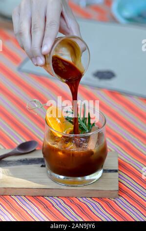 Versando espresso, succo d'arancia e caffè espresso shot Foto Stock