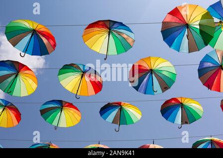 Molti rainbow ombrelloni messi di fronte alla strada Foto Stock