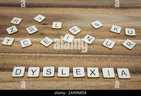 Close up della lettera in legno piastrelle con la parola dislessia nella parte inferiore del telaio Foto Stock