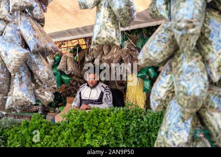 Marrakech, Marocco - 7 gennaio 2020: Fornitore di prodotti all'aperto che vendono menta fresca e erbe secche per preparare il tè marocchino Foto Stock