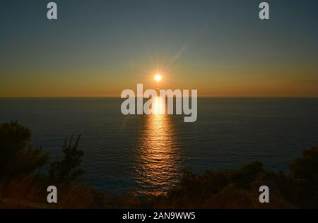 Tramonto sul mare, il blu del cielo terso orizzonte e buio superficie del mare con tramonto riflesso Foto Stock