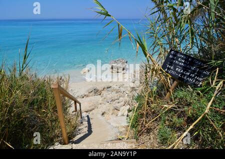 Tenere pulito attenzione all'ingresso di una spiaggia, iscrizione sulla lavagna: la spiaggia non è di auto pulite, sia in inglese e greco Foto Stock