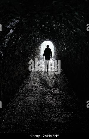 Camminando attraverso il tunnel sotto il Molo di Llanfoist e il Wharfinger's Cottage sul Monmouthshire e sul Brecon Canal nel Brecon Beacons South Wales UK Foto Stock