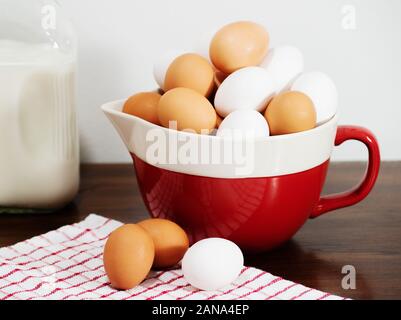 Foto rustico di una ciotola piena di marrone e bianco uova. Foto Stock