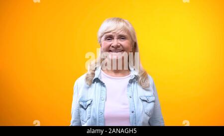 Gentile vecchia signora sorridente sulla fotocamera, concetto di cliente soddisfatto, buon servizio Foto Stock