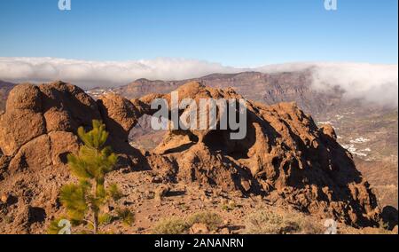 Gran Canaria, curiosamente a forma di arco in pietra Ventana del Bentayga, cloudfall oltre il bordo della Caldera de Tejeda Foto Stock