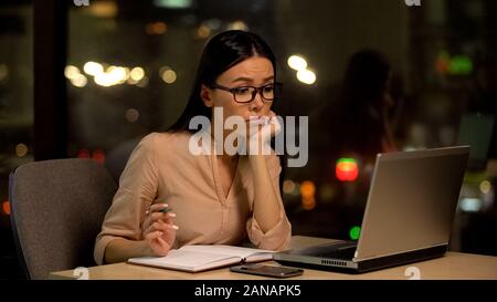 Triste giovane femmina occhiali la ricerca di lavoro online, la mancanza di idee, lavorare esaurimento Foto Stock