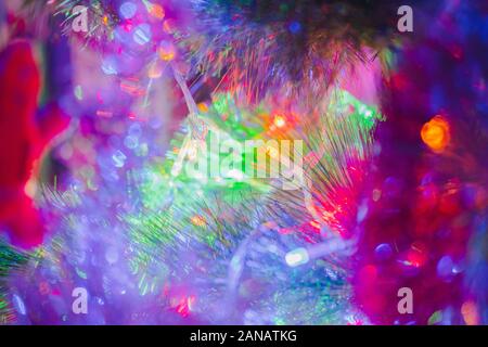 Nuovo anno luci in abete rami, vista da vicino. Shot dettagliati di orpelli natalizi e decorazioni Foto Stock