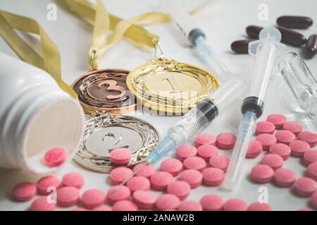 Pila di farmaci in pillole e iniezioni di sport e medaglie. Concetti di uso della Droga e doping nello sport per migliori prestazioni Foto Stock