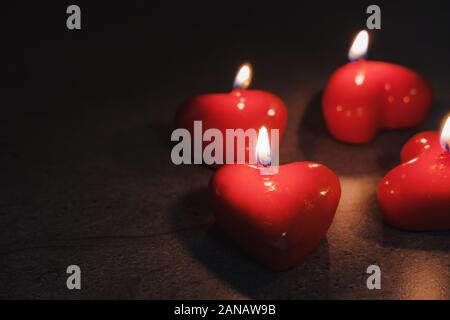A forma di cuore ad candele bruciano nelle tenebre. Concetto di il giorno di San Valentino Foto Stock